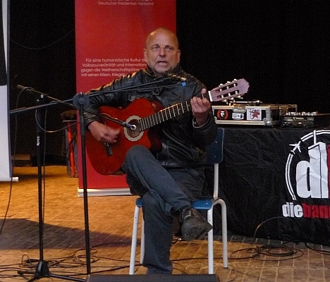 Mit Gitarre auf der Bühne sitzend - Foto: © 2013 by Schattenblick